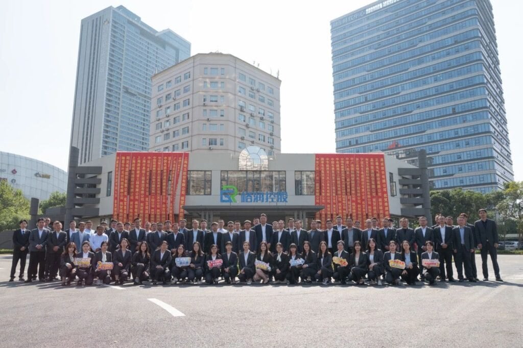 Green Holdings Employees Group Photo Outside New Office Building, Celebrating Corporate Relocation