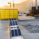 PORTA foldable solar container deployed at a construction site with tower cranes in background